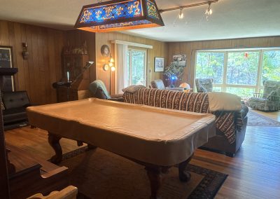Rustic game room with pool table, stained glass light, and Native American decor at Travel Magick Spiritual Retreat Center main house Colorado