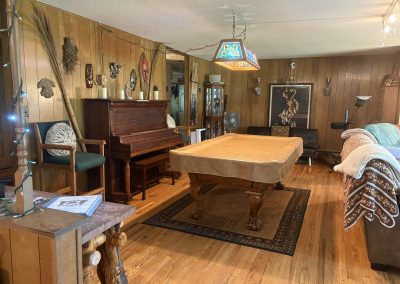 Rustic game room with pool table, stained glass light, and Native American decor at Travel Magick Spiritual Retreat Center main house Colorado