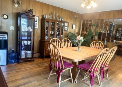 Spacious dining room with large wooden table and purple cushioned chairs at Travel Magick Spiritual Retreat Center main house Colorado