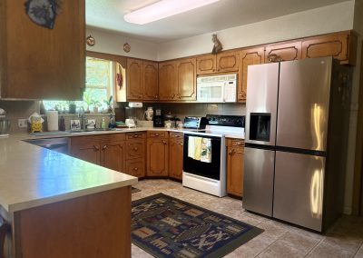 Fully equipped kitchen with modern appliances and wooden cabinets at Travel Magick Spiritual Retreat Center main house Colorado