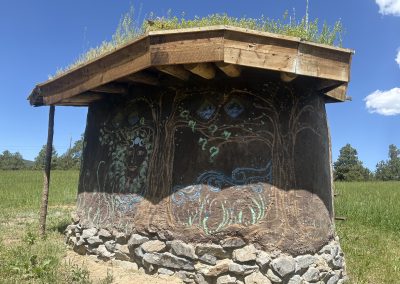 Hand-built earth building with living roof and sacred animal