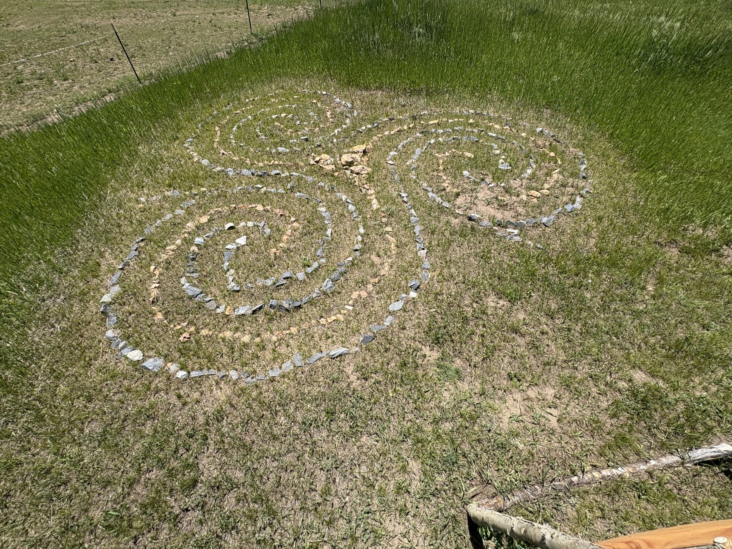 Sacred stone labyrinth with spiral pattern in mountain meadow at Travel Magick Spiritual Retreat Center Colorado