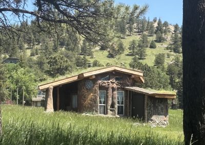 Hand-built earth building cabin with sacred geometry murals constructed by hosts at Travel Magick Spiritual Retreat Center Colorado